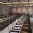 Konferenzraum mit Tischen, Stühlen, Wasserflaschen, Äpfeln und Schreibmaterial