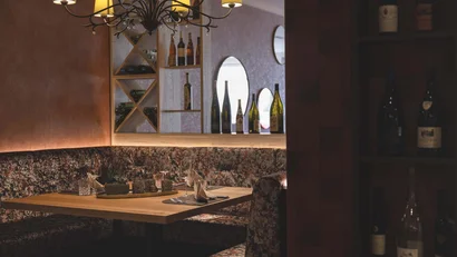 Gemütliche Restaurant-Ecke mit Weinflaschen und warmem Kronleuchterlicht