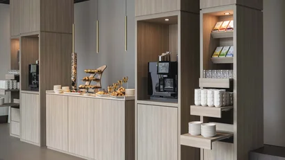 Modernes Kaffee- und Snackbuffet mit Holzregalen und Beleuchtung