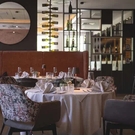 Elegantes Restaurant mit gedeckten Tischen und Weinflaschen an der Wand