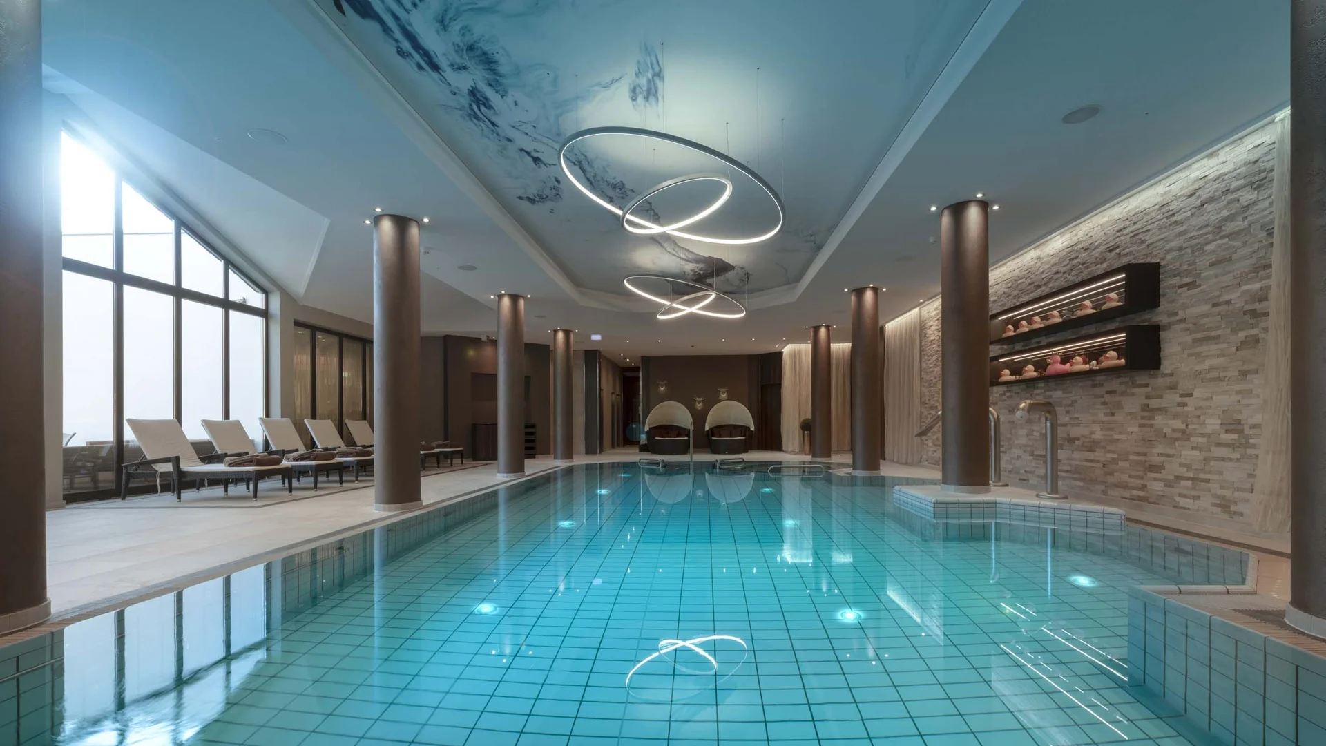 Moderner Innenpool mit loungestühlen und einzigartiger Deckenbeleuchtung