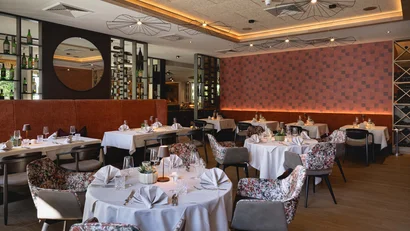 Elegantes Restaurant mit gedeckten Tischen und moderner Beleuchtung
