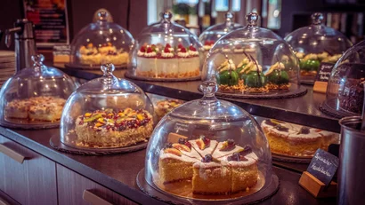 Verschiedene Kuchen unter Glasglocken auf einem Ladentisch