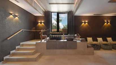 Modernes Spa mit Holztreppe, dekorativen Hirschfiguren und warmen Wandlampen