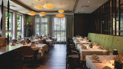 Elegantes Restaurant mit gedeckten Tischen und warmen Hängelampen