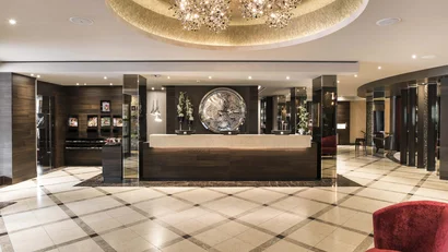 Moderner Hotel-Empfangsbereich mit großer Uhr und Kristalllüster