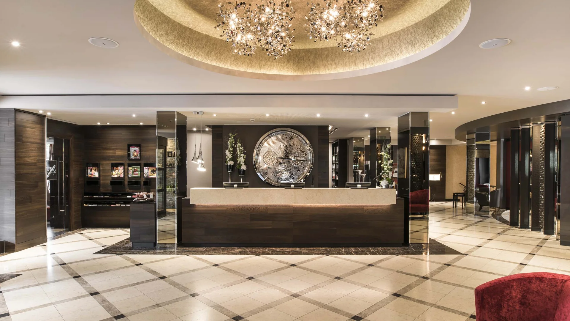 Moderner Hotel-Empfangsbereich mit großer Uhr und Kristalllüster