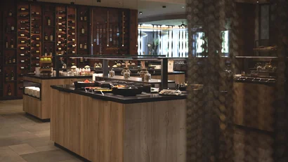 Elegantes Buffet mit Weinregal und verschiedenen Speisen in modernem Restaurant