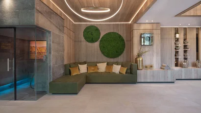 Moderner Wartebereich mit grünem Sofa und Wanddekoration aus Moos