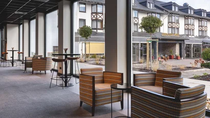 Moderne Lounge im Hotel mit Blick auf den Haupteingang und Garten