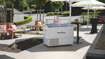 Eisverkaufsstand mit Sonnenschirmen und Sitzbereich im Freien