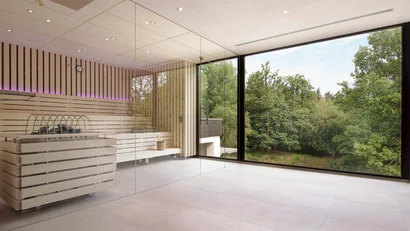Moderne Sauna mit Glaswand und Blick auf grünen Wald
