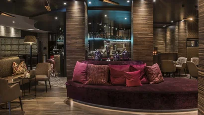 Elegante Hotelbar mit Samtsofa und stilvoller Beleuchtung