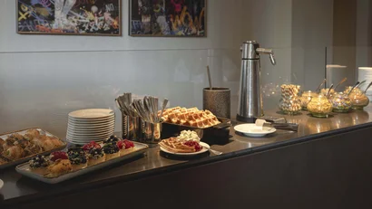 Buffet mit Waffeln, Kuchen und Utensilien in einem Café