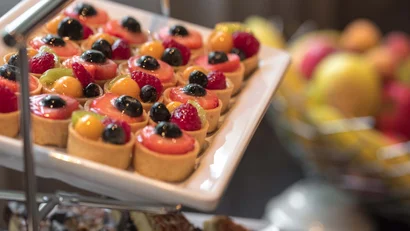 Verschiedene kleine Frucht-Törtchen auf einem weißem Tablett