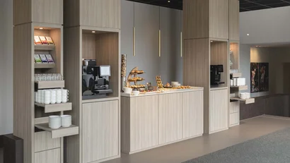 Modernes Kaffee- und Snackbuffet mit Holzregalen und Beleuchtung